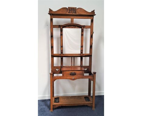 1930s OAK HALL STANDwith a shaped and carved top rail above a rectangular central mirror flanked by three pairs of metal coat