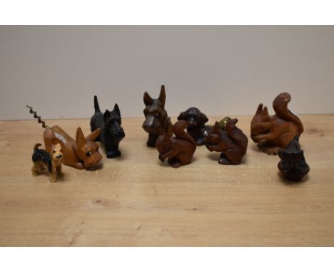 A group of carved dog and squirrel figures, one with corkscrew tail, sold together with a pottery dog figure, cast dog figure