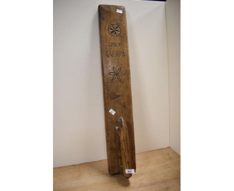 A vintage hand carved mangle board having 'J.A.P.A.P.D' 1822 to the front, measuring 77cm in length.
