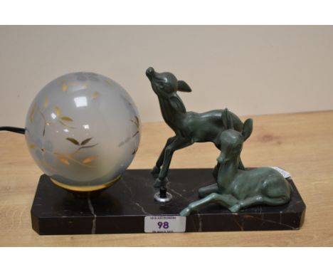 An Art Deco variegated black marble and cast patinated metal desk light, of canted rectangular form with two stylised fawns a