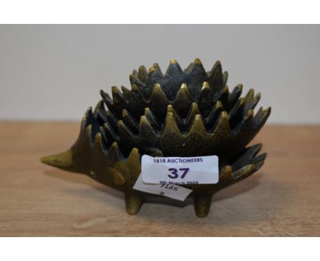 A graduating set of 6 vintage hedgehog brass ashtrays, stackable with spike backs, largest L12cm