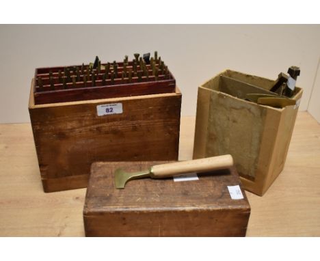 A good selection of wooden handled brass leather working tools, various including rose design, type set letters, with fitted 