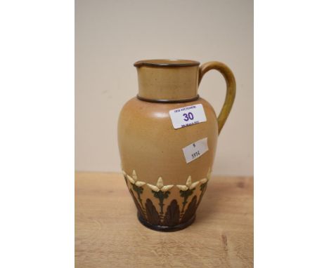 A late 19th century Doulton Lambeth stoneware pitcher in the Arts and Crafts style, partly decorated with floral motifs, impr