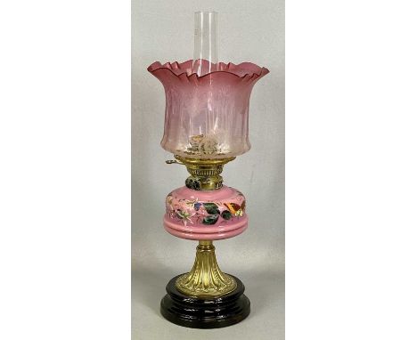 LATE 19TH CENTURY OIL LAMP, black ceramic base, embossed brass stem, painted pink opaque glass reservoir, etched pink and cle