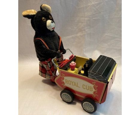 Tinplate: A vintage battery operated, bear pushing pram, good working condition, baby loose in pram.