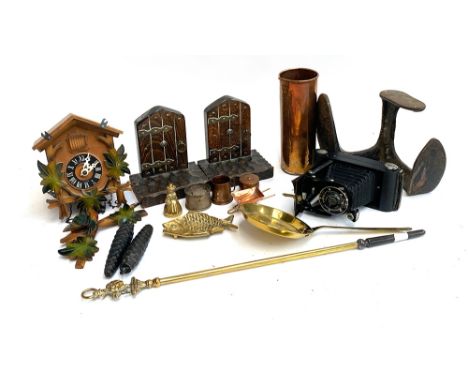 A mixed lot to include bookends, cuckoo clock, Kodak junior bellows camera, cast iron shoe slob, brass fire poker etc 