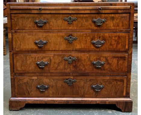 A Georgian and later walnut veneer bachelor's chest, cross and featherbanded, comprising brushing slide over four graduating 
