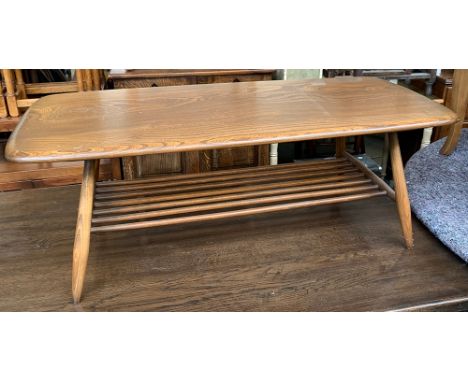 A mid century Ercol coffee table, with spindle turned undershelf, on splayed legs, 104x46x37cmH 