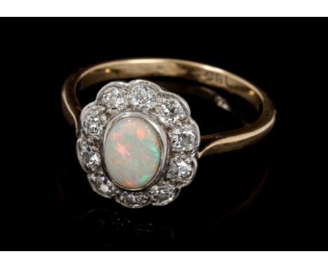 Opal and diamond cluster ring, the oval cabochon opal surrounded by ten old cut diamonds, on plain shank.  Estimated total di