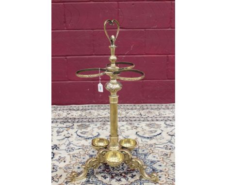 Ornate Victorian-style brass stick stand with loop handle and central knopped reeded column with three circular rings and res