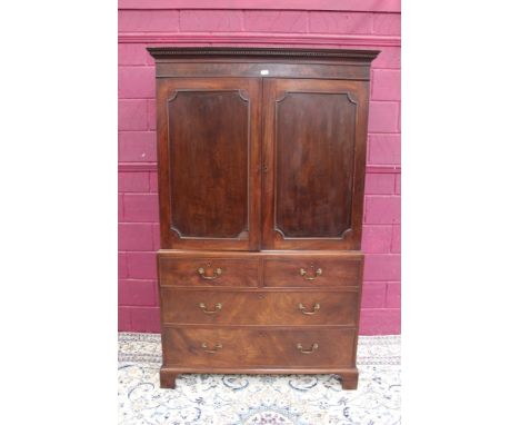 George III mahogany linen press, having dentil moulded cornice and interior of slides enclosed by panelled doors, the base wi