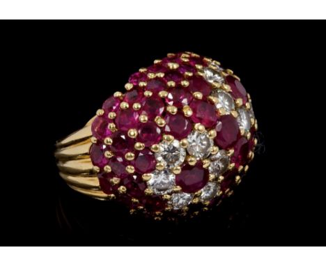1960s Kutchinsky 18ct gold diamond and ruby cocktail ring of bombe form with two flower-head clusters on a pavé set ruby grou