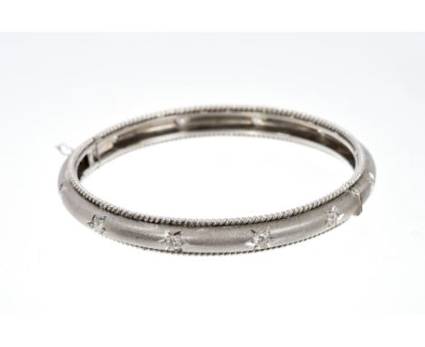 Indian white metal and diamond hinged bangle with twelve brilliant cut diamonds in star-shape settings, with ropetwist edge. 