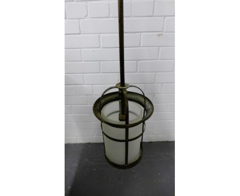 Light fitting on a single long brass arm with an opaque glass shade within a basket lantern holder, approx 155cm long