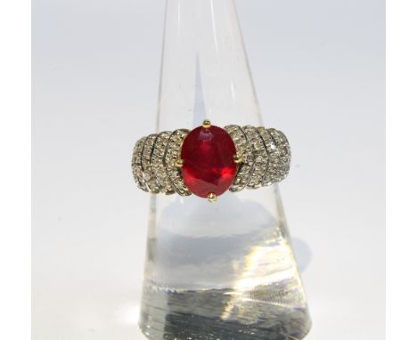 9ct gold ruby and diamond cocktail dress ring by Rocks &amp; Co with an oval claw set ruby flanked by five graduating rows of