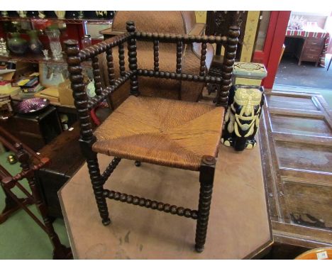 A 19th Century bobbin turned corner chair with rush seat