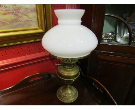A brass oil lamp with glass shade