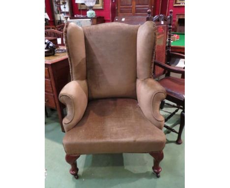 A 19th Century walnut wingback fireside armchair the scroll arms over pad foot cabriole legs and ceramic castors, 105cm tall 