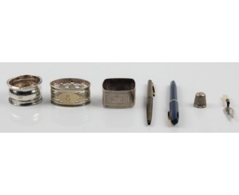 Two hallmarked silver napkin rings, an EPNS napkin ring, a thimble stamped Sterling, a hallmarked silver trowel design bookma