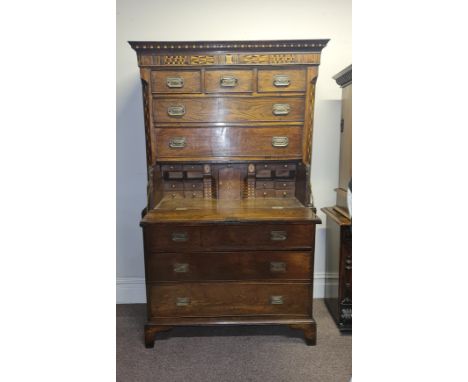 A 19th century oak secretaire chest on chest fitted with three drawers to base, two long, three short and one fitted secretai