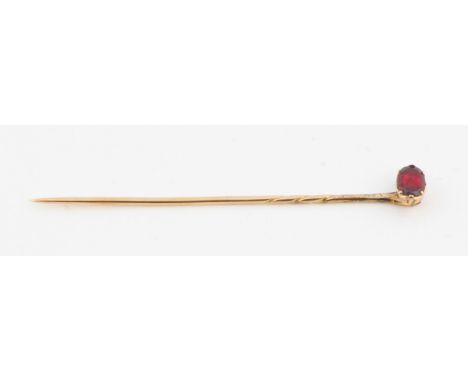 A garnet set stick pin, unmarked yellow metal, in fitted box. IMPORTANT: Online viewing and bidding only. No in person collec