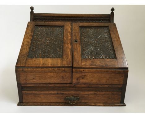 An oak writing and letter box with fitted interior including inkwell decorated with carved leaf design to front doors, approx