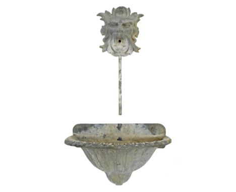 Antique cast lead garden fountain, the spout in the form of a mask into a bow fronted trough with darted borders and fluted b