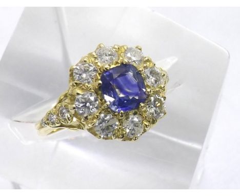 Good 18ct sapphire and diamond cluster in yellow gold, the sapphire 1.25ct approx, in a claw setting with a surround of round