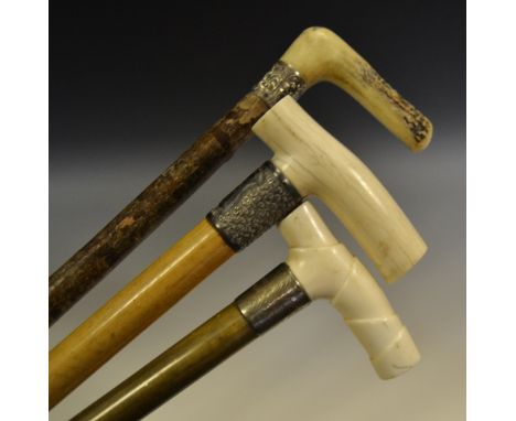 A late 19th century walking stick, horn handle;  others, silver collars 