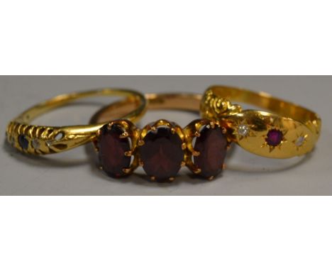 An 18ct gold gypsy ring set with a central ruby and two diamonds; another trilogy ring set with a sapphire and two diamonds w