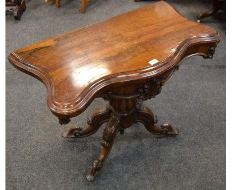 A rosewood serpentine card table, folding top, green leather playing surface, lobed baluster column, four cabriole legs.