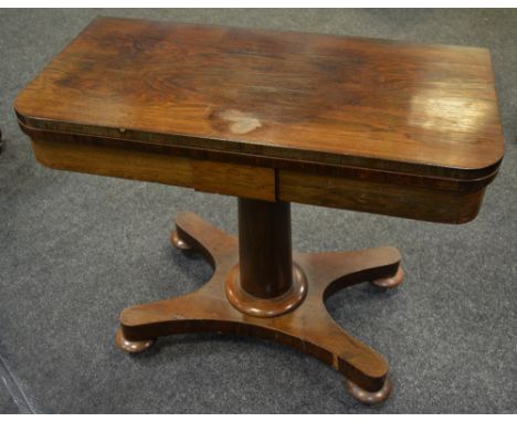 A Victorian rosewood card table, green baize playing surface, spreading cylindrical column, quatrefoil base, bun feet, brass 