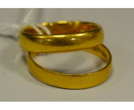 A 22ct gold barrel shaped wedding ring; another flat (gross weight 7.8g)