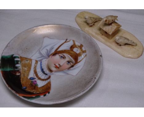 A Continental porcelain small dish with portrait design, and a bone carving