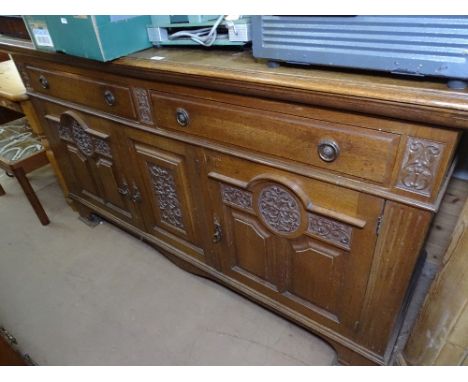 A 1920s oak sideboard, raised panelled back, drawers and panelled cupboards under on bracket feet, W 183cm