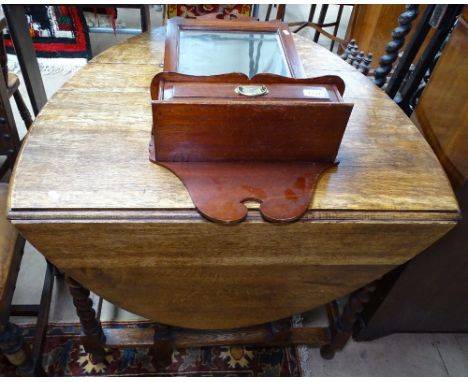 An oak oval gateleg table, and a mahogany framed wall mirror with fitted drawer