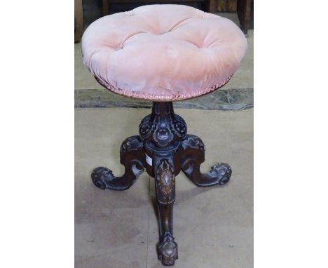 A Victorian carved walnut revolving music stool