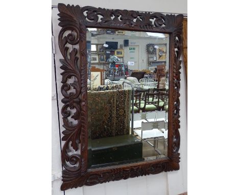 A French carved and pierced oak framed wall mirror, with pediment