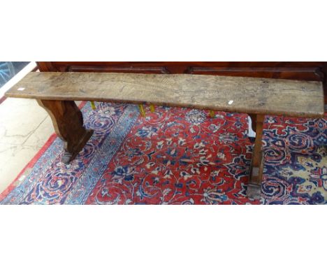 An Antique elm bench seat on shaped end supports, length 5'