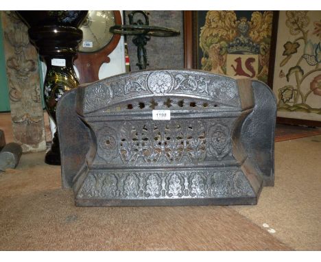 A cast iron fire grate front with foliate decoration, 22" wide x 12" tall.