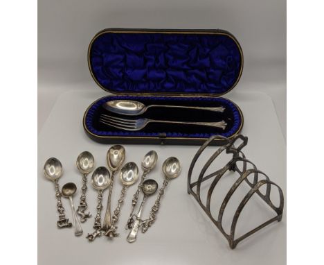 A cased silver spoon and fork hallmarked Birmingham 1900, together with a silver toast rack, along with silver and white meta