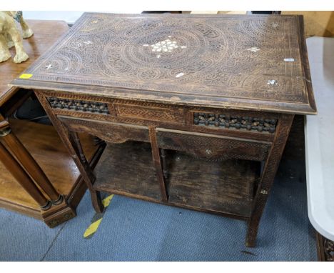 A 19th century Indian teak two tier side table inlaid with mother of pearl and heavily carved with geometric designs, 81cm h 