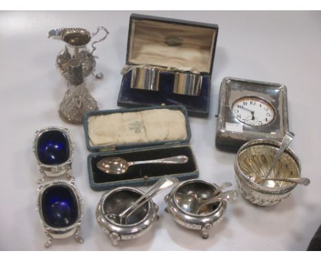 A Georgian silver cream jug with later repousse decoration, 2 pairs of silver salts, a desk clock, napkin rings etc, includin