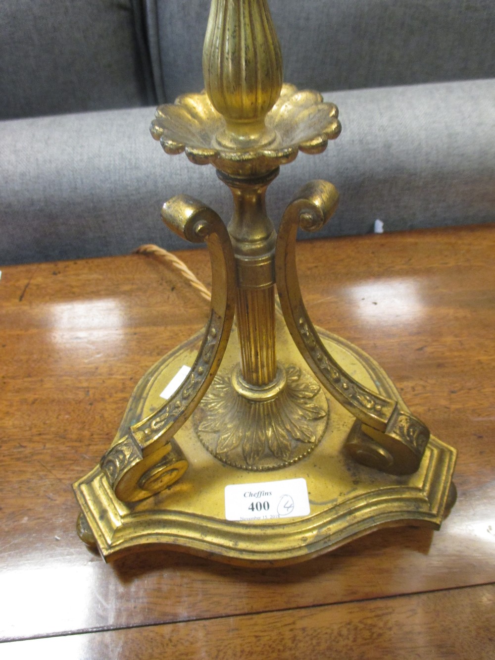 Two brass Edwardian table lamps with glass shades; an American brass reading lamp and a brass in