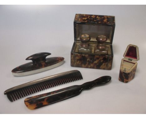 A 19th century tortoiseshell perfume casket, containing two glass bottles, the hinged covers painted with European scenes; a 