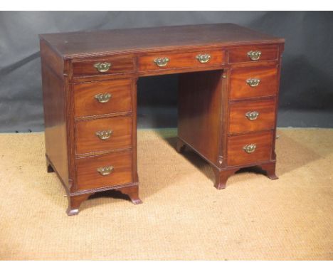 A George III style mahogany kneehole desk with canted reeded sides with brass handles on swept bracket feet, 79 x 118 x 59cm 