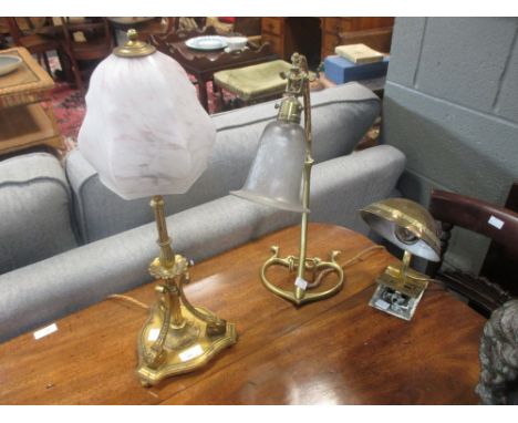 Two brass Edwardian table lamps with glass shades; an American brass reading lamp and a brass magazine rack (4)  