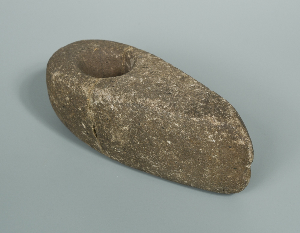 A Neolithic stone axe head in Cheffins Fine Art