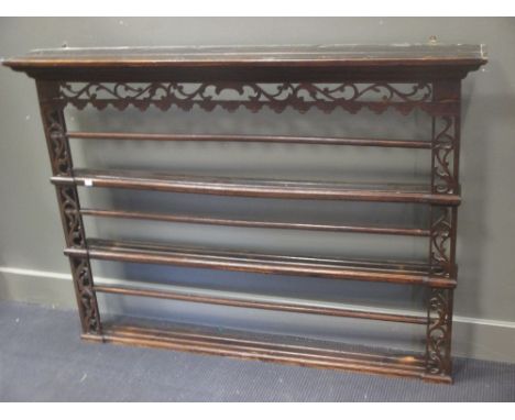 An oak three-shelf wall hanging plate rack, with scroll carved detail and moulded cornice, 133cm wide, 106cm high  