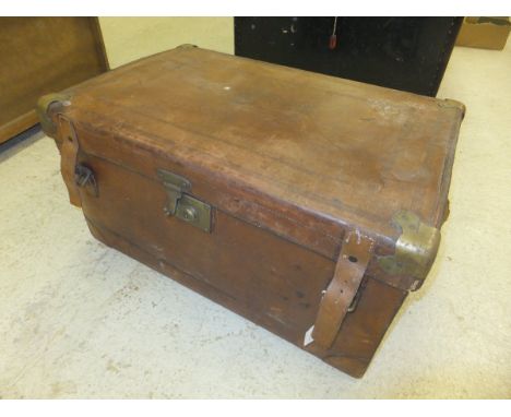 A vintage brown leather metal-bound travelling trunk with fitted interior